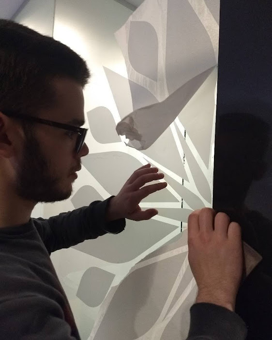 Persona colocando un vinilo decorativo mural